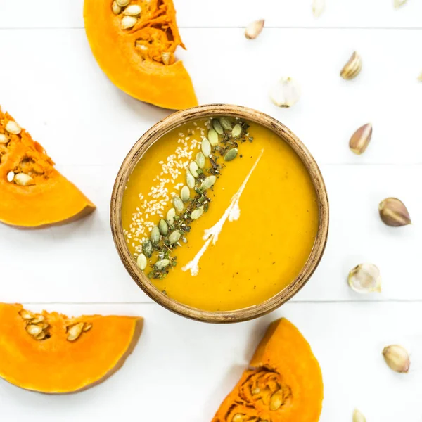 balkabağı çorbası bir kil tabak kabak çekirdeği, susam, baharat ve krema ile dekore edilmiş
