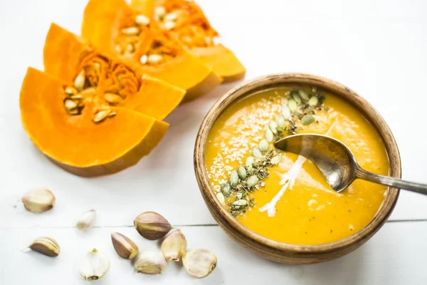 balkabağı çorbası bir kil tabak kabak çekirdeği, susam, baharat ve krema ile dekore edilmiş