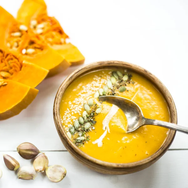 balkabağı çorbası bir kil tabak kabak çekirdeği, susam, baharat ve krema ile dekore edilmiş