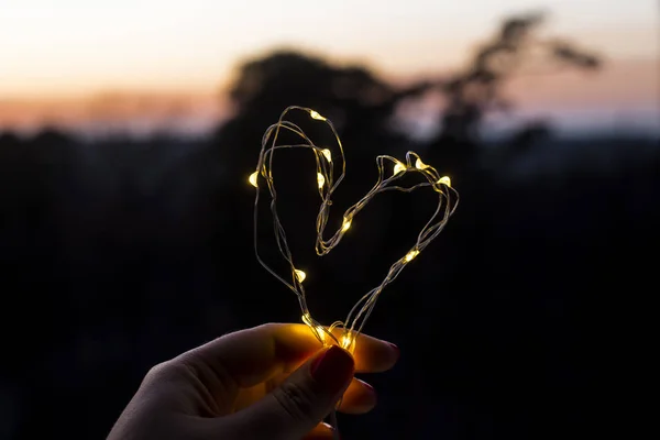 Het symbool van de liefde - het hart van de krans in de handen — Stockfoto