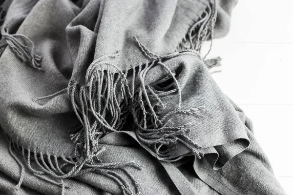 背景纹理的皱巴巴的灰色冬天时尚女性围巾 在白色的木桌上 — 图库照片