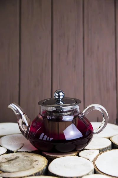 Karkade 与浆果在一个透明的茶壶在木桌上 乡村风格 — 图库照片