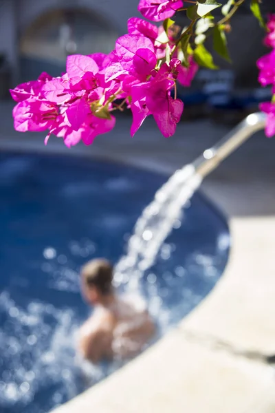 A man enjoys hydro massage in a large spa pool