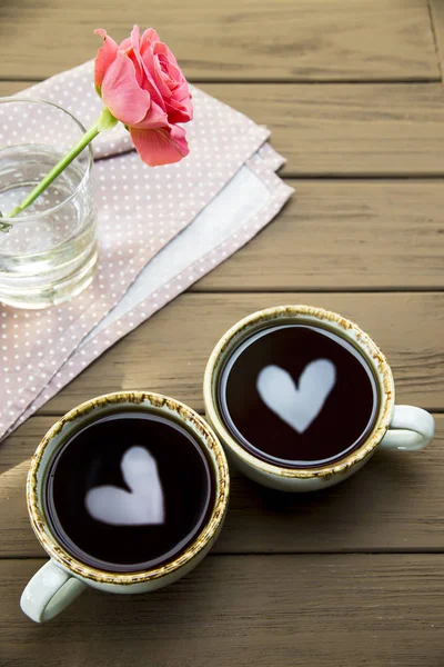 Two hearts are reflected in two cups of coffee. Valentine\'s Day Concept