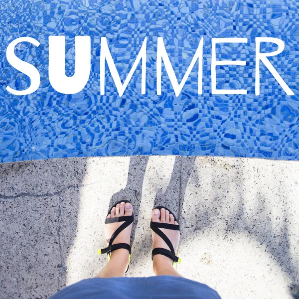 Female feet in summer sandals near the pool. Summer concept. The word summer is written on the photo