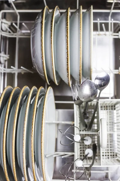 Clean cutlery in the dishwasher. Home equipment. Work at home concept
