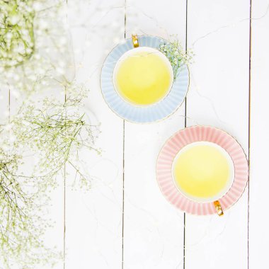 Hassas vintage bardak pembe ve mavi beyaz arasında çay ile gypsophila çiçek kurutulmuş. Ev iç ve natürmort concept. Üstten Görünüm. Flatlay