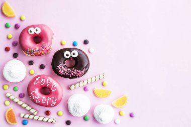 Abur cubur. Çörek, marmelat, çikolata sopa ve topları ve pembe bir arka plan üzerinde beze. Sağlıksız yiyecek konsepti. Üstten Görünüm. Boşaltmak