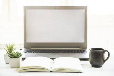 Beyaz masa üstünde bir defter ile laptop monitör işyerinde. Minimalist tasarımı. Güneş ışığı - kolay renklendirme