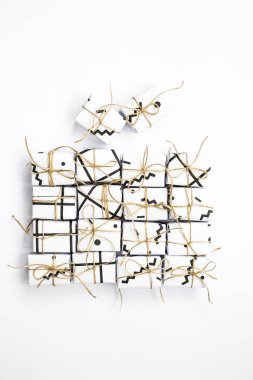 Küçük hediye kutuları ile bağlı siyah geometrik desenleri ile beyaz renkteki sicim. Beyaz bir arka plan üzerinde. Üstten Görünüm, düz yatıyordu