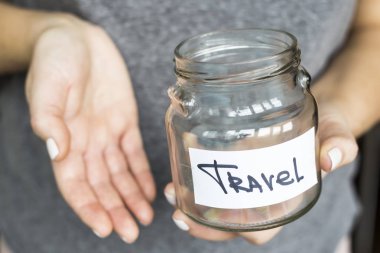 A woman is holding an empty piggy bank for travel. No money concept clipart
