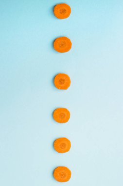 Havuç mavi bir arka plan üzerinde parlak yuvarlak elebaşı. Sağlıklı gıda kavramı. Üstten Görünüm, düz yatıyordu