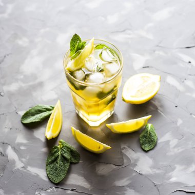 Cam cam buz, nane ve limon gri beton zemin üzerine soğuk çay ile. Yaz soğutma içeceği