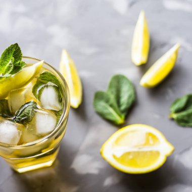 Cam cam buz, nane ve limon gri beton zemin üzerine soğuk çay ile. Yaz soğutma içeceği. Üstten Görünüm, düz yatıyordu