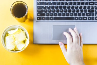 Cips ve cola laptop vardır. Bir kadın sağlıksız abur cubur lazım. İş arasındaki tatilinde snack