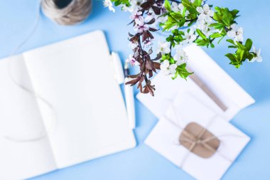 Bir buket bahar dal üstünde mavi bir arka plan bir defter ile işyerinde