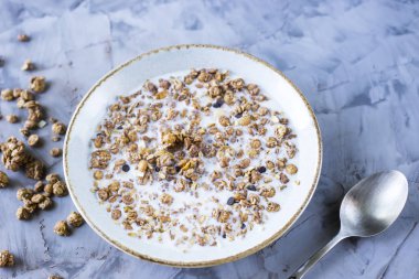 Çikolata müsli süt bir plaka üzerinde gri bir tablo ile. Lezzetli Sağlıklı Kahvaltı