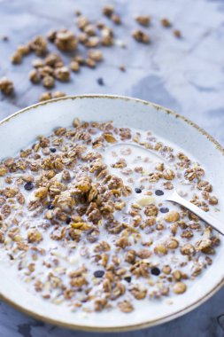 Çikolata müsli süt bir plaka üzerinde gri bir tablo ile. Lezzetli Sağlıklı Kahvaltı