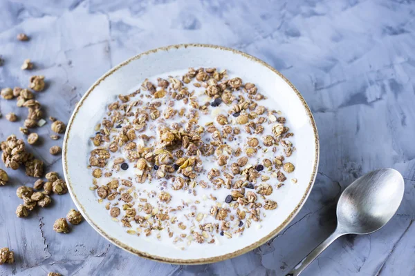 Çikolata müsli süt bir plaka üzerinde gri bir tablo ile. Lezzetli Sağlıklı Kahvaltı