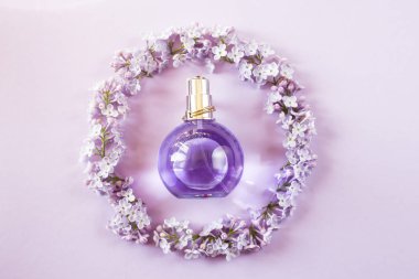 Menekşe leylak çiçek yanındaki kadın parfüm şişe. Kadınlar için Bahar nazik koku. Üstten Görünüm, düz yatıyordu