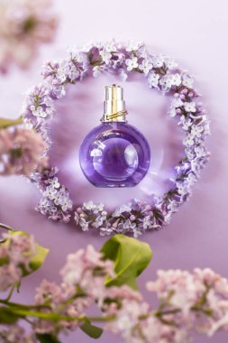 Menekşe leylak çiçek yanındaki kadın parfüm şişe. Kadınlar için Bahar nazik koku. Üstten Görünüm, düz yatıyordu