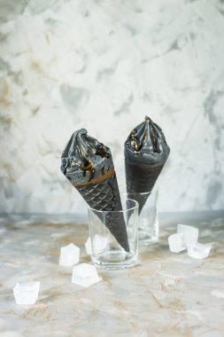 İki dondurma waffle koniler gri bir arka plan üzerine siyah. Yaz trend tatlı