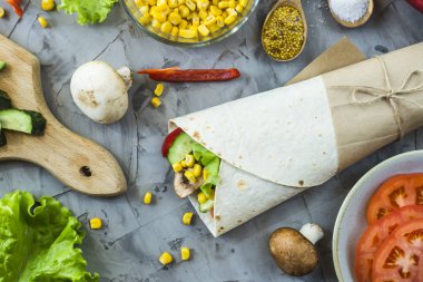 Vejeteryan dürüm sebze, mantar ve ekmeği. Gri bir masada malzemeler arasında