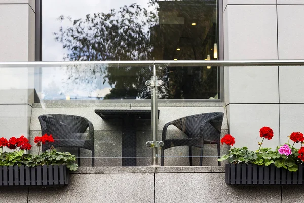 Red geranium in flowerpots on the terrace of a modern business center