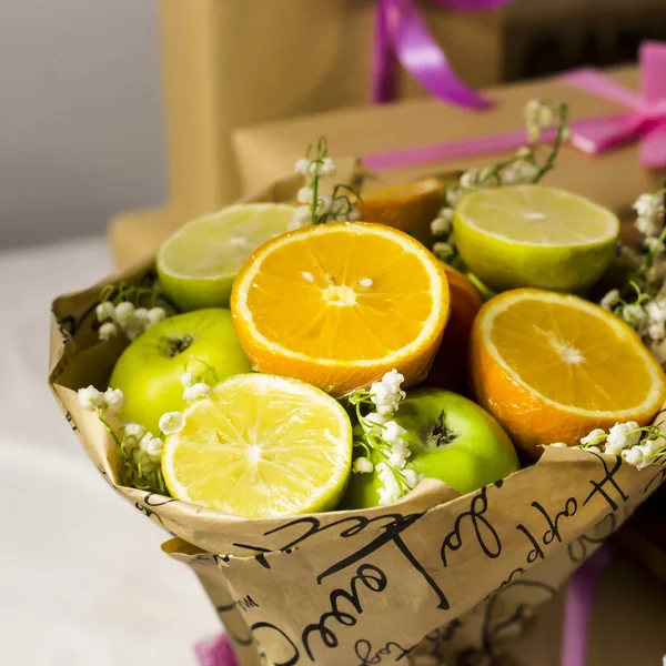 Fruit bouquet with oranges, apples and flowers