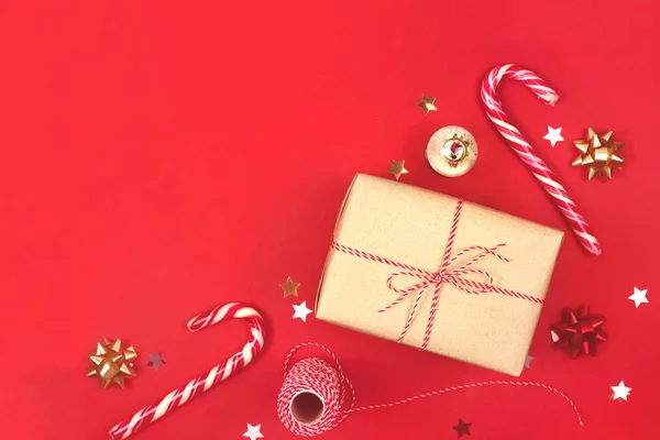 Різдвяна розкладка з подарунком в крафтовій упаковці на червоному . — стокове фото