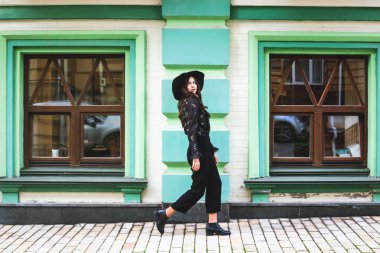 Siyah şapkalı bir kız sonbaharda ya da ilkbaharda şehirde dolaşır..