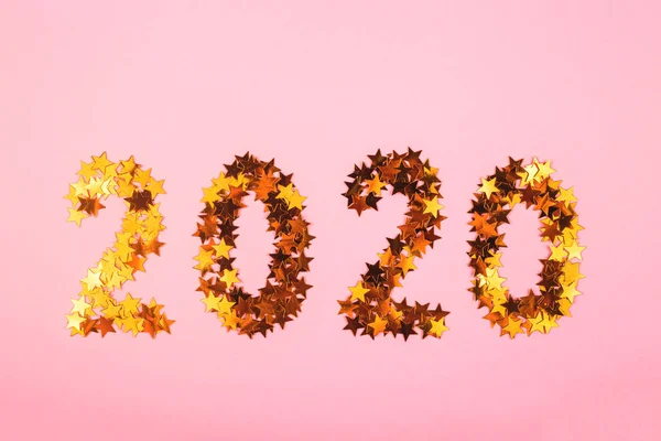 Новый год 2020 Новогодний символ золотых конфетти на розовом ковре . — стоковое фото