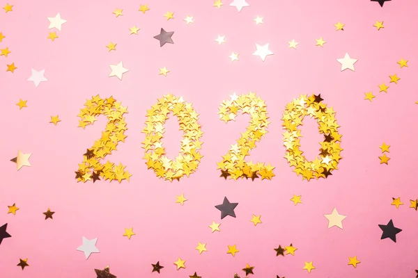2020 Simbol tahun baru emas confetti di tanah merah muda . — Stok Foto