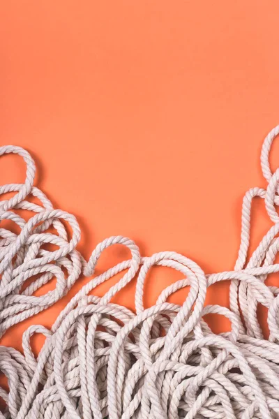 Minimalistisch katoen witte touw achtergrond met textuur en contrast op heldere koraal achtergrond. — Stockfoto