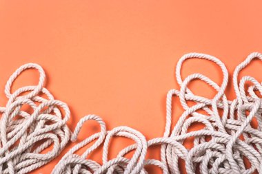 Parlak mercan zemin üzerinde dokusu ve kontrastı olan minimalist pamuk beyaz halat arkaplanı.