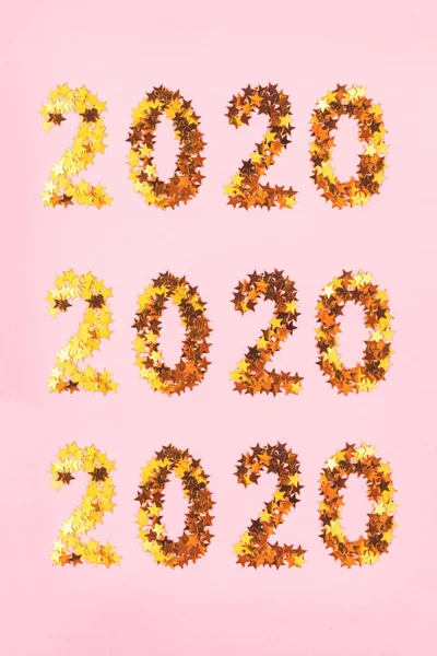 2020 Nytt år symbol för guld konfetti på rosa ackground. — Stockfoto