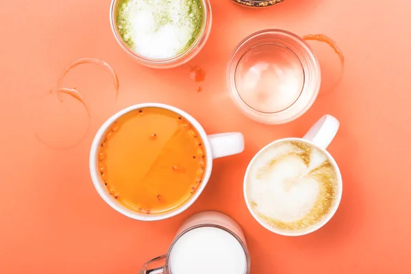Kopjes koffie, thee, sap en water. Ochtenddrankjes voor verschillende voorkeuren. Bovenaanzicht. — Stockfoto
