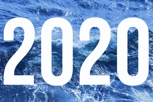 2020 is geschreven in het wit op een achtergrond van blauwe zee golven. — Stockfoto