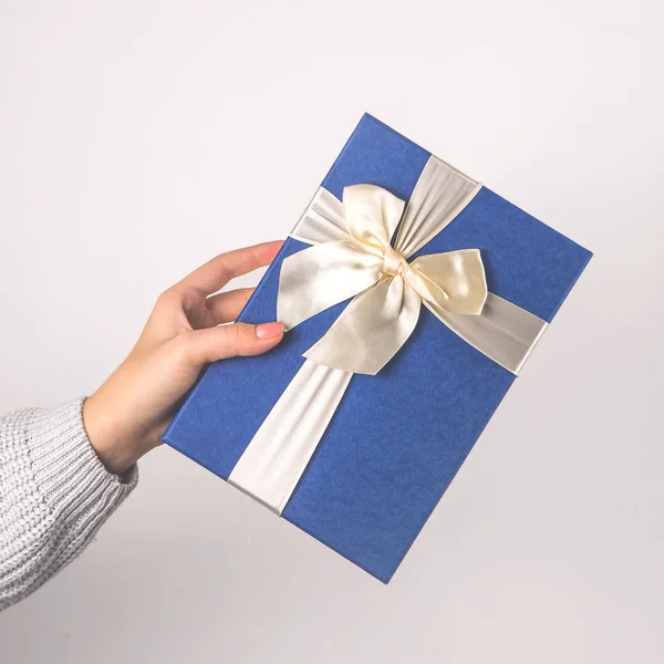 女性の手に贈り物と長方形の青い箱. — ストック写真