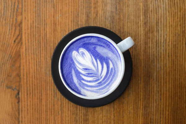 Niebieskie cappuccino ze sztuką w białym kubku. Widok z góry, zbliżenie. — Zdjęcie stockowe