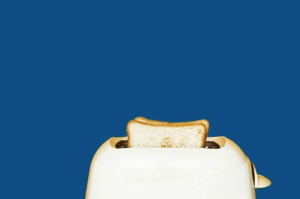 Тостер с белым поджаренным хлебом на синем классическом фоне . — стоковое фото