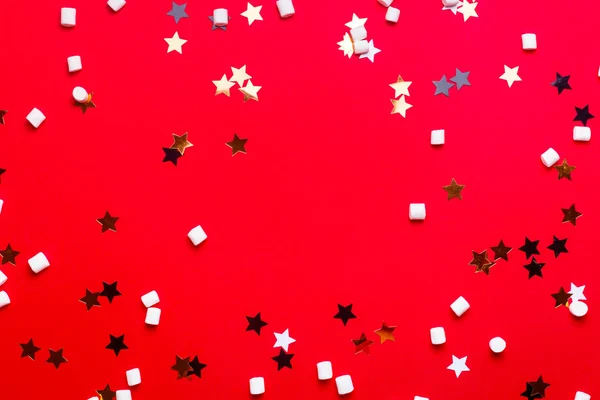 Fundo de Natal com estrelas e marshmallows no vermelho . — Fotografia de Stock