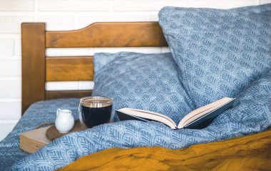 Bir tepsi kahve ve süt sürahisi ile klasik mavi yatak.