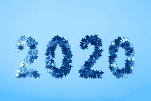 2020 New Year symbol of gold confetti on blue background. — Stock Photo, Image
