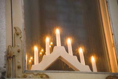 Avrupa 'da minimalist Noel süslemesi Pencerenin yanında yedi mum için bir şamdan.