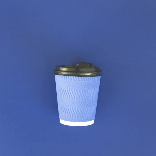 Blue paper cup for coffee on a blue background.