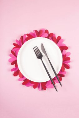 Sevgililer Günü için kalpleri olan pembe arka planda yuvarlak boş bir tabak..