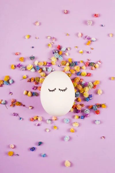 Portrait of an easter egg among flowers on purple. — Stock Photo, Image