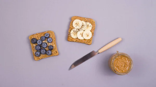 Desayuno vegetariano saludable con mantequilla de maní, fruta y superalimentos . — Foto de Stock