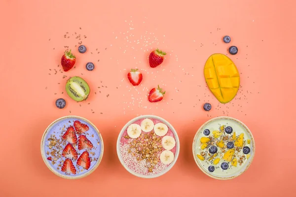Alimentation saine végétarienne à base de smoothies multicolores avec des allumettes et des baies sur un fond rose vif . — Photo